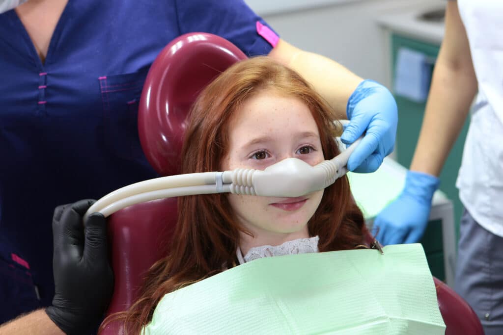 Little girl receiving inhalation sedation for dental treatment in a clinic during PVPD Sedation Dentistry in Arizona